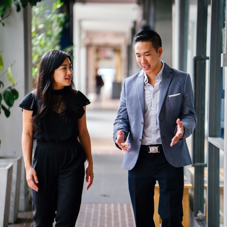 two business people walking outside office building
