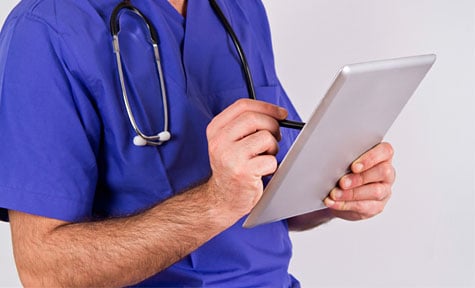 doctor looking at records on a device