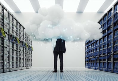 A man is standing in a server room with his head in a digital cloud