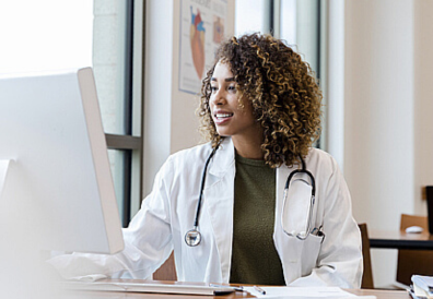 A smiling doctor looking at her computer