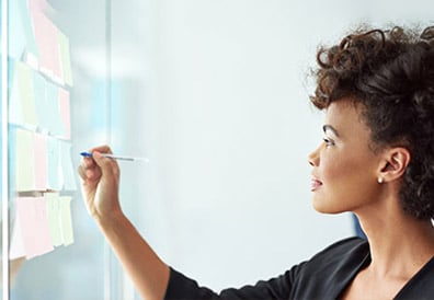 A woman writing on a whiteboard A woman writing on a whiteboard