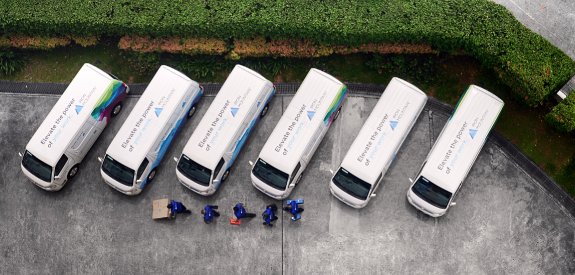 Overview of parked Iron Mountain trucks with drivers moving data