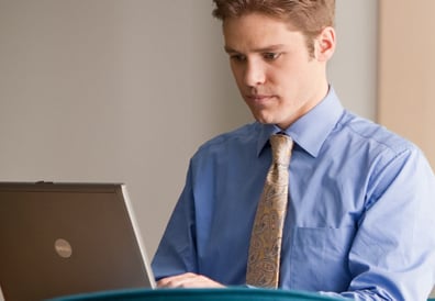 Man in tie looking at a laptop