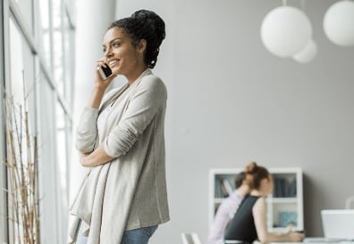 A woman talking on mobile phone in a sunny office