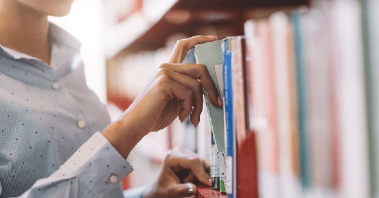 Library services solution brief - woman pulling book from bookshelf