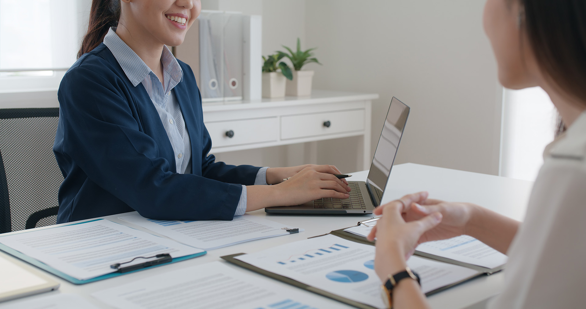 a consultant on laptop showing loan paperwork to client