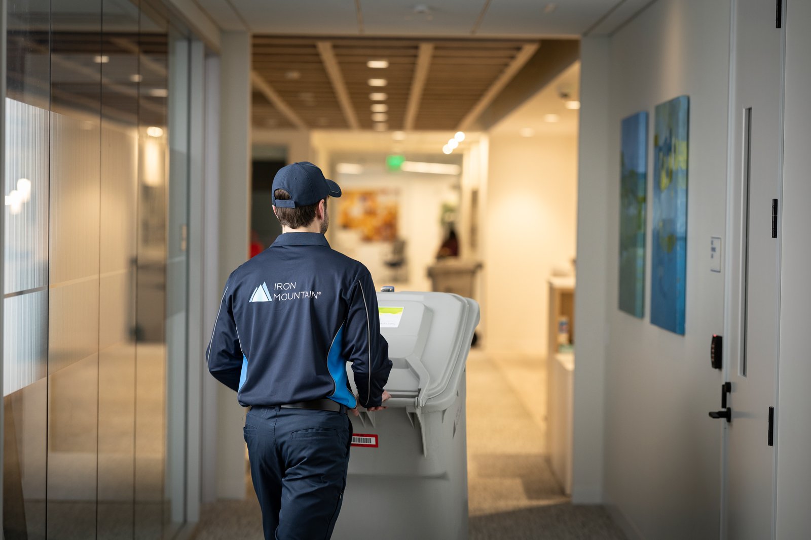 Iron Mountain employee moving shred bin to secure offsite shredding locaton