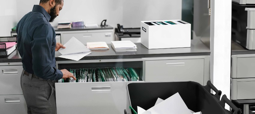 Employee prepping paper files for shredding