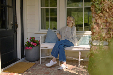 A person sitting on a porch and talking on the phone