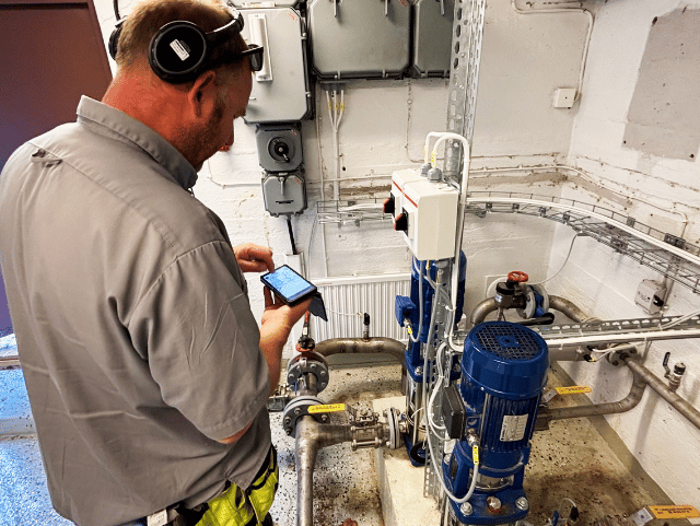 A person uses a mobile phone to monitor a pumping station