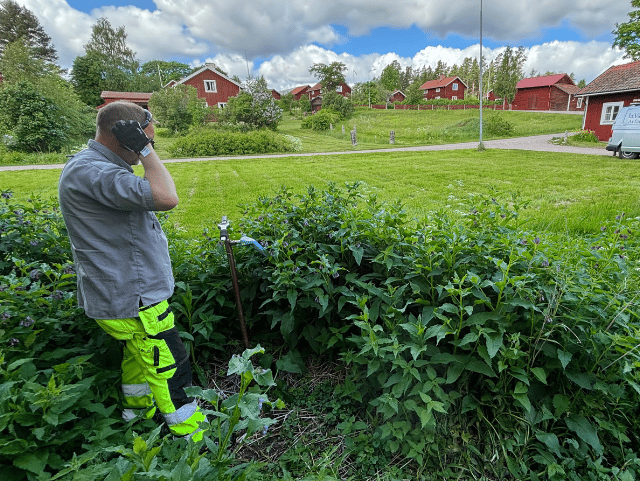 Person performing measurements outdoors in a green environment.