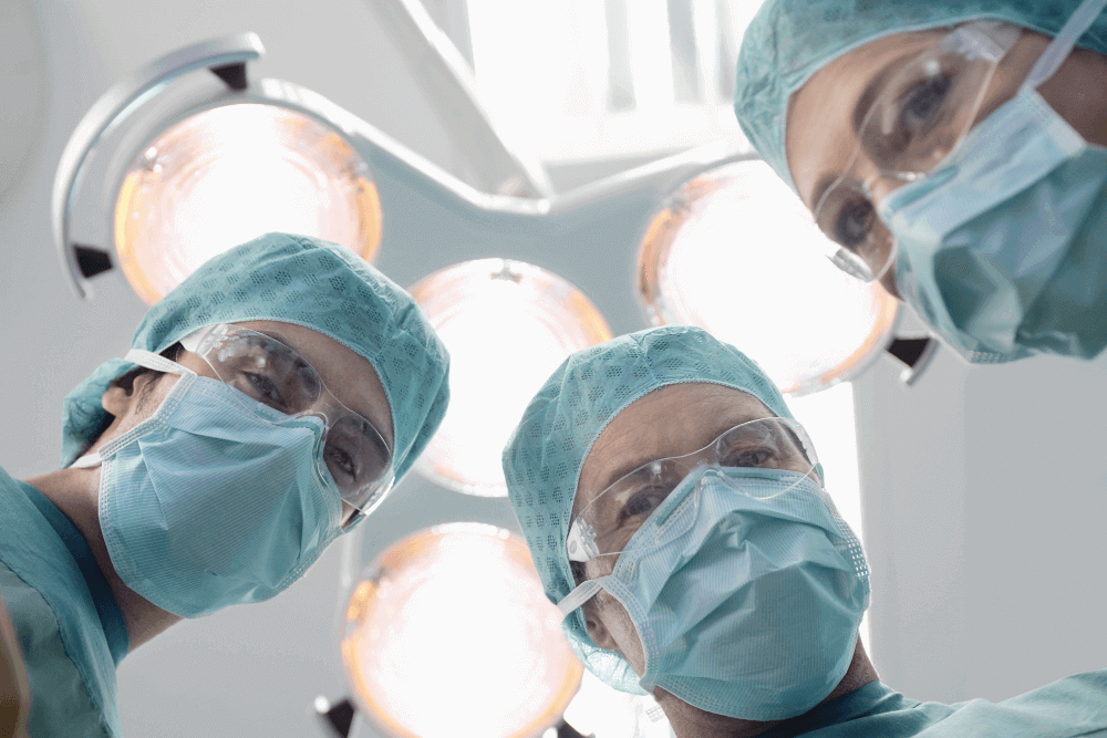 Three surgeons looking down at the camera