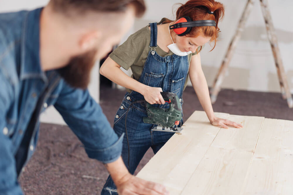 A DIYer couple cutting timber