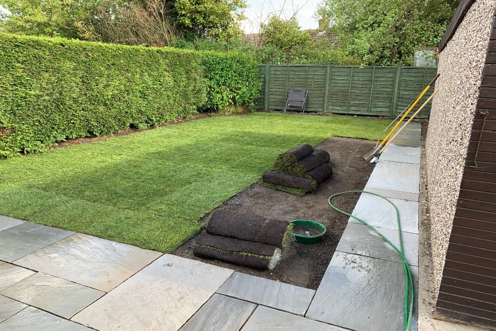 DIYers backyard with fresh new grass being laid