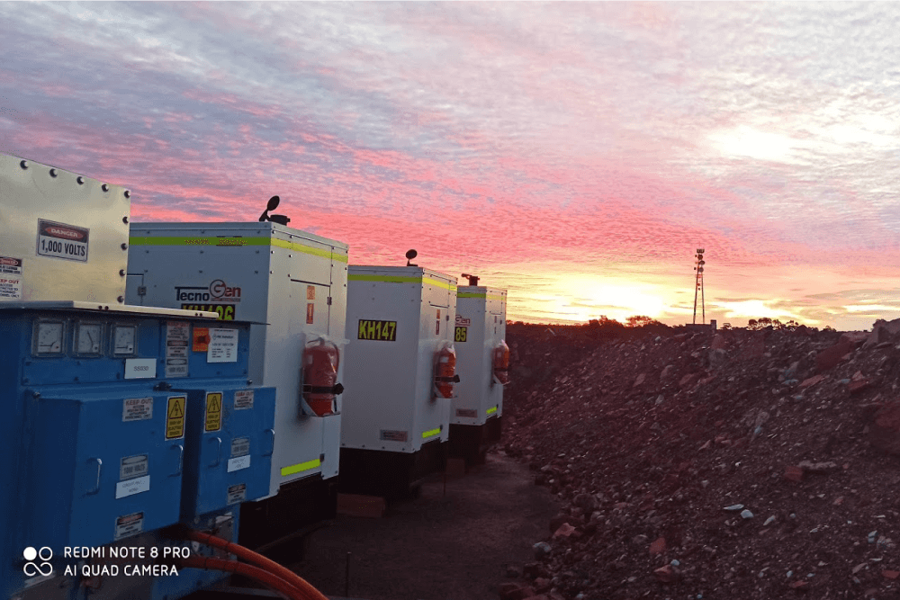 Generators at a site with sunset behind