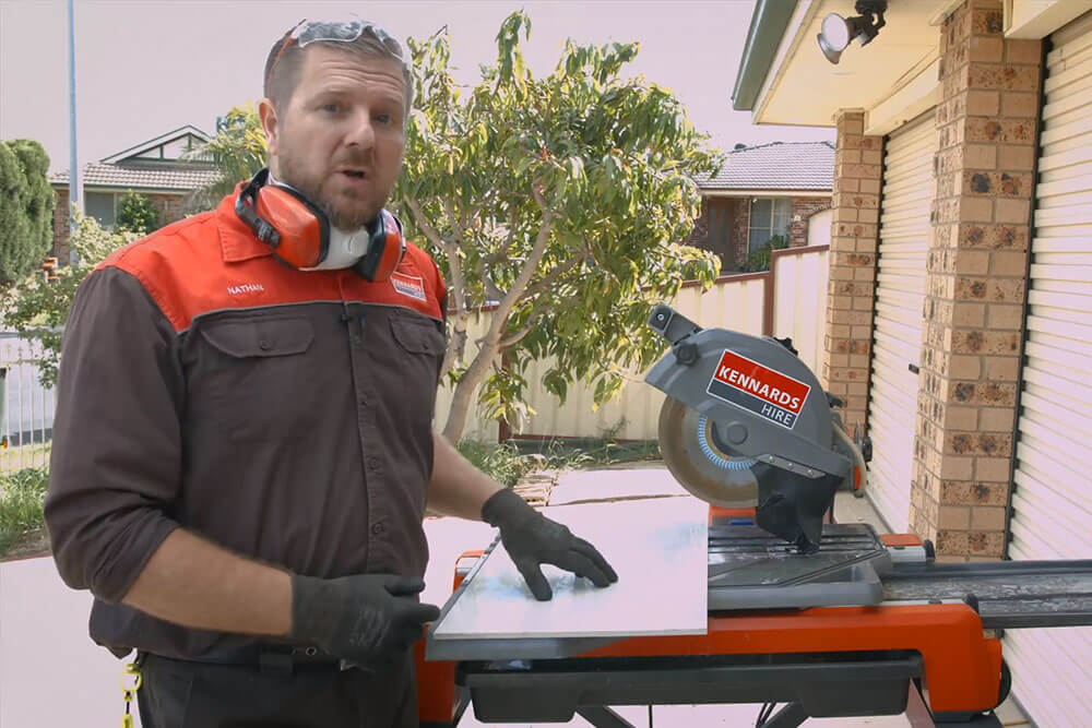 A Kennards Hire employee using a tile saw