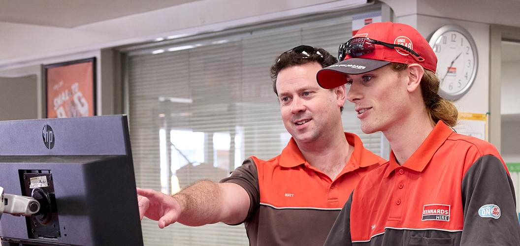 Kennards Hire team members looking at a computer in branch