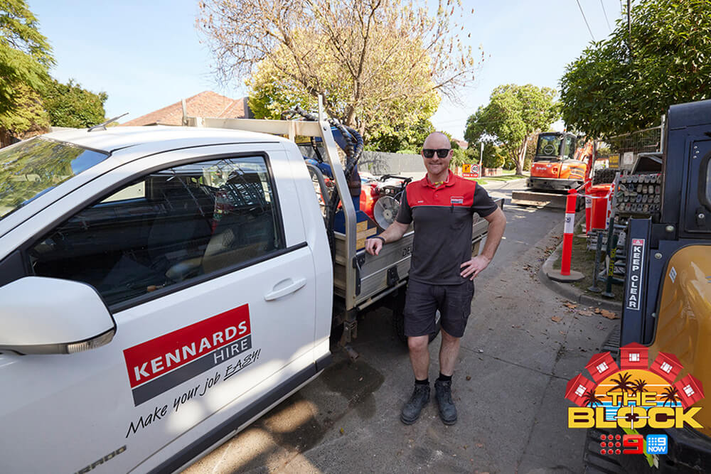 A Kennards Hire team member standing next to a ute