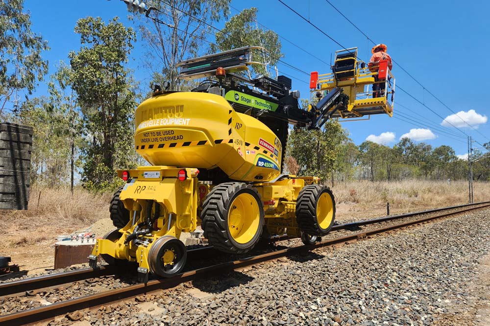 Worker using rail equipment on a rail line