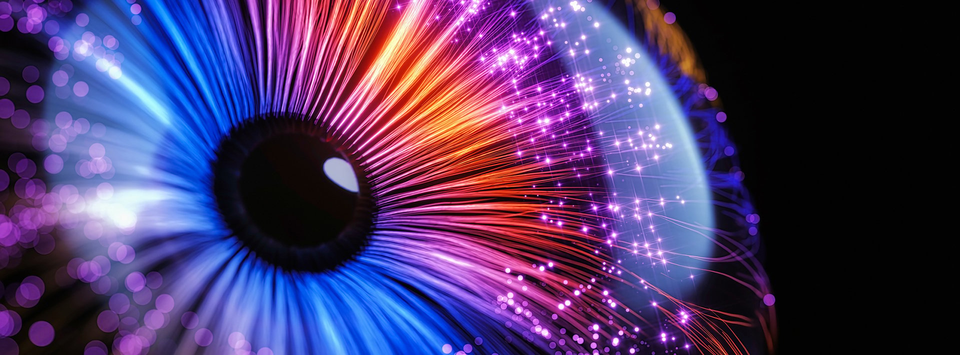 Lewis Silkin Illustration on a black background of an eye formed of light, its iris is a red to blue circular gradient with a black pupil