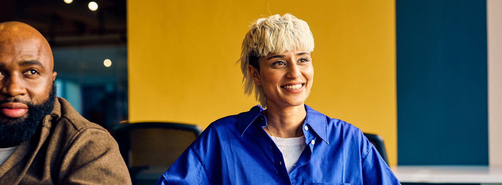 Lewis Silkin Young smiling people in casual dress sitting with laptops in an office environment
