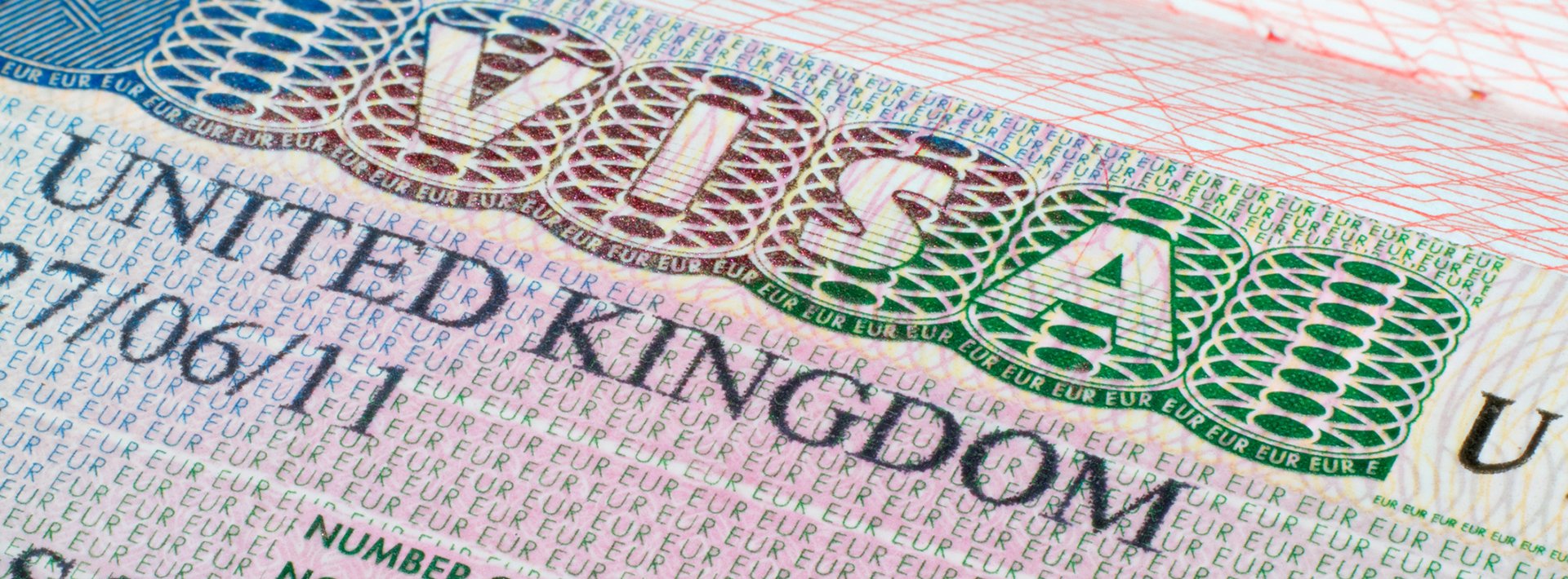 Lewis Silkin Close up of a UK visa document, it is pink in colour covered in complex patterns of letters & shapes in greens and blues