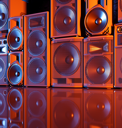 Lewis Silkin A row of large speakers of various designs bathed in orange and blue light