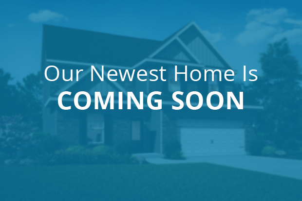 Our newest home is coming soon text overlaid on an out-of-focus two-story home image