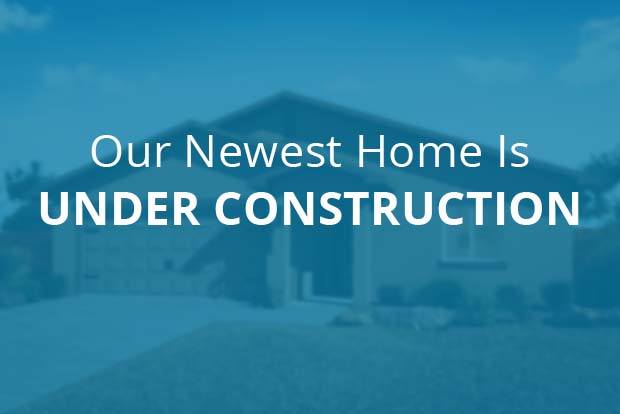 Our newest home is under construction text overlaid on out-of-focus home rendering