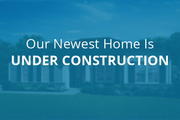 Our newest home is under construction text overlaid on out-of-focus home image