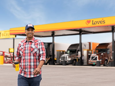 A driver walking in front of a diesel bay canopy at Love's