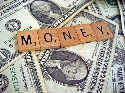 dollar bills with scrabble letters