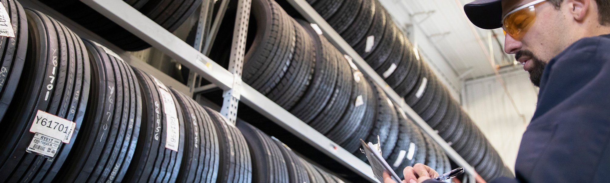 An employee in front of commercial truck tires