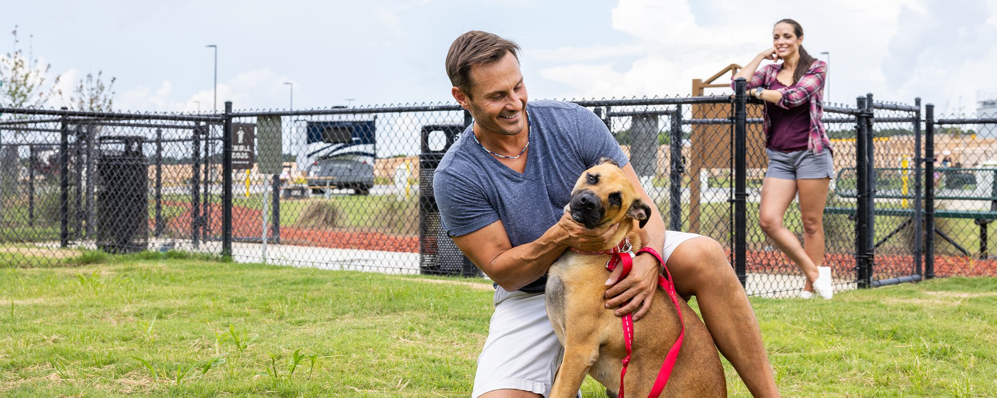 A photo of a family and their dog in a dog park