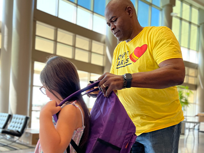 Love's Travel Stops Corporate volunteer giving backpack to young girl
