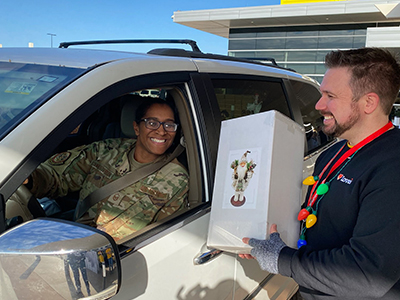 Love's Travel Stops volunteer handing gift to military service woman