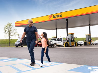 a father and daughter at a love's with the gas canopy in the background