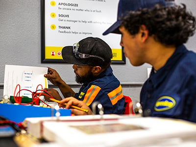 Two men working with wires at the Truck Care Academy