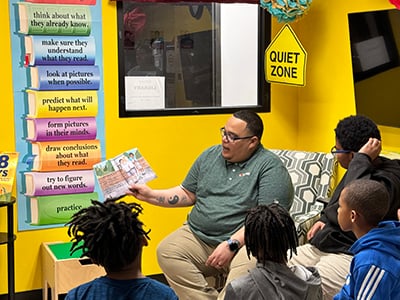 A photo of a Love's employee reading to students at Urban League of Greater Oklahoma City