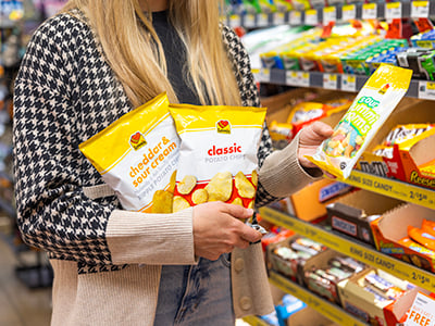 A customer holding Love's Chips and Bagged Candy in a Travel Stop