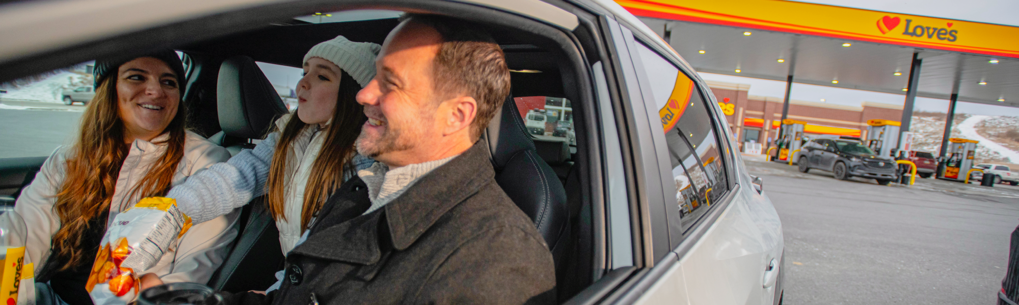 Image of family enjoying some Love's Snacks with a Love's Travel Stop and Love's Gas Canopy in the background