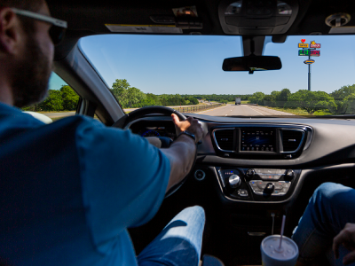 A customer driving with a Love's highway hi-rise in the view