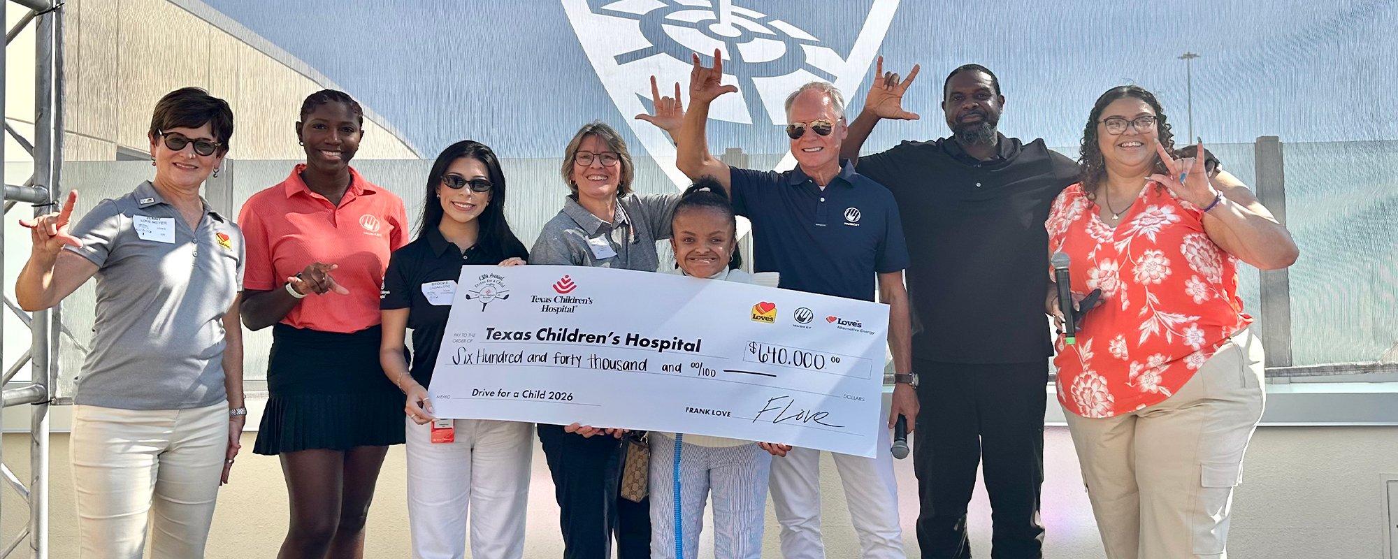 Child receiving Texas Children's Hospital check from Musket Corp. and Love's Alternative Energy annual fundraiser golf tournament