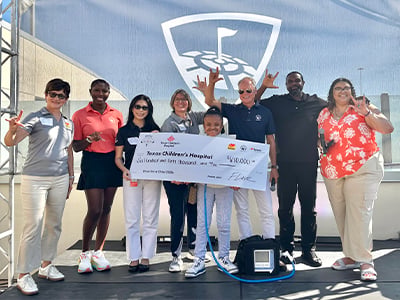 Child receiving Texas Children's Hospital check from Musket Corp. and Love's Alternative Energy annual fundraiser golf tournament