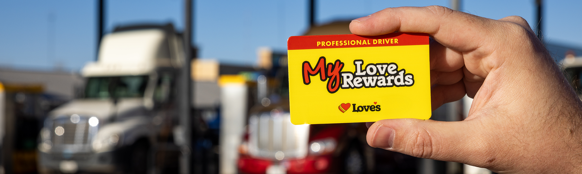 My Love Rewards Card in front of commercial trucks