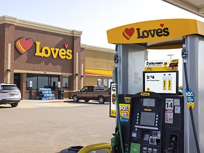 Love’s Travel Stop with a fuel pump in the foreground and the store building and Love’s logo visible in the background.
