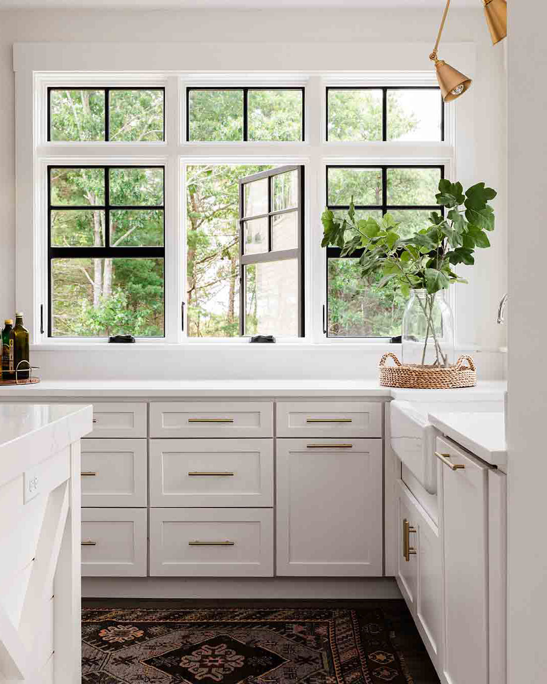 A white kitchen with an open Marvin Elevate Casement Window