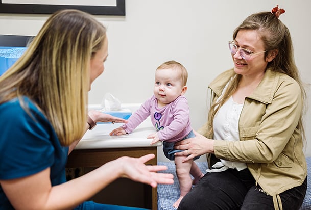 Mother with infant talking to health care provider