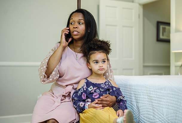 Mother holding child while on a call with a nurse