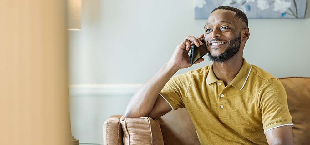 Man in yellow shirt talking on phone